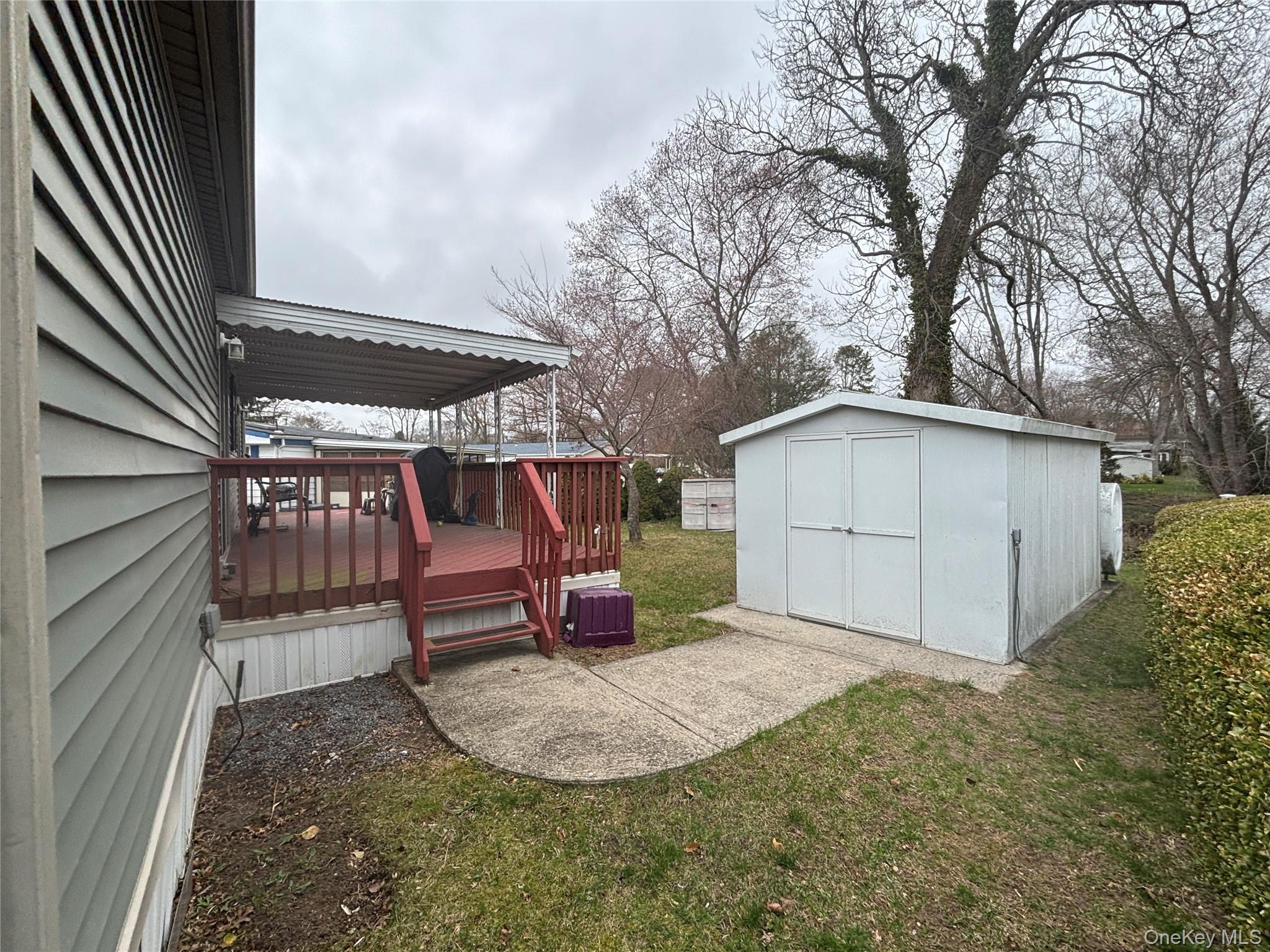 1661 Old Country Road, Unit 417 Riverhead, NY 11901 - Photo 7 of 20 a view of a backyard with a barbeque and wooden fence