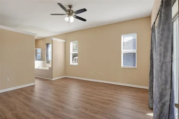 a view of an empty room with window and wooden floor