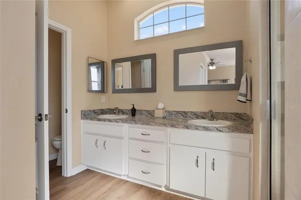 a bathroom with a granite countertop double vanity sink and mirror