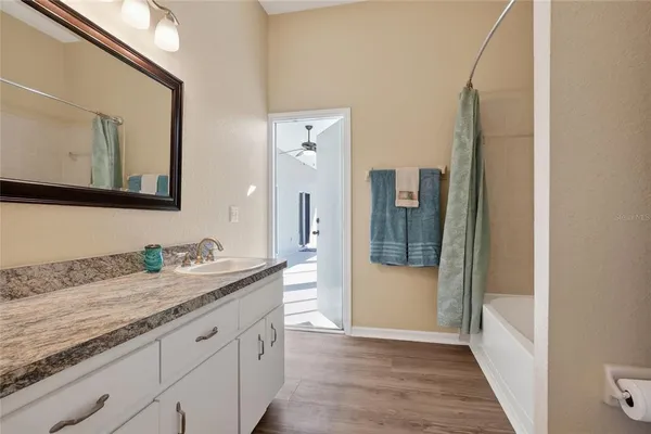 a bathroom with a granite countertop sink and a mirror