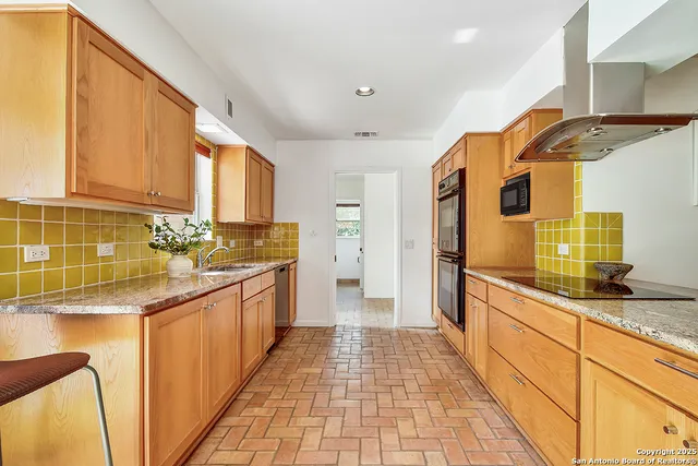 a kitchen with stainless steel appliances granite countertop a sink and cabinets