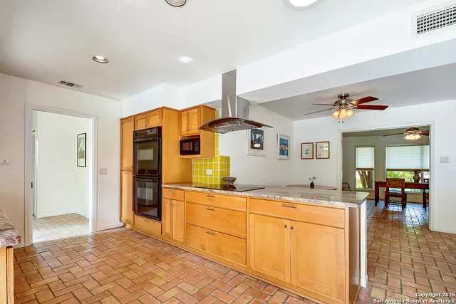 a kitchen with stainless steel appliances kitchen island granite countertop a refrigerator and cabinets