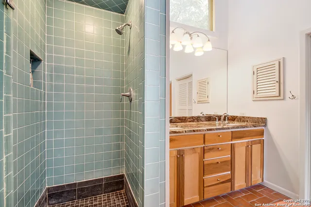 a bathroom with a granite countertop sink a mirror and shower