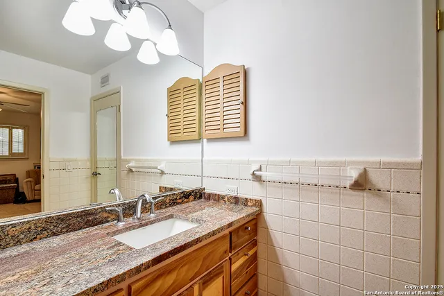 a bathroom with a granite countertop sink and a mirror