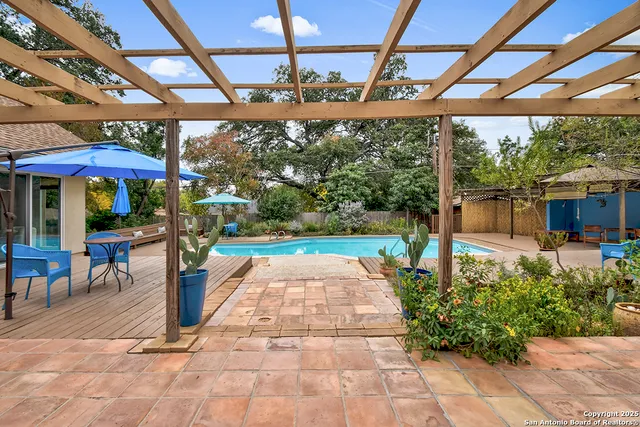 a view of a patio with a table and chairs under an umbrella