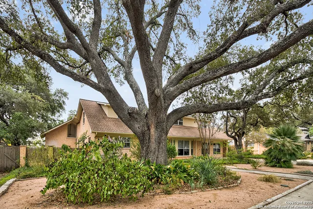 a front view of a house with yard and trees