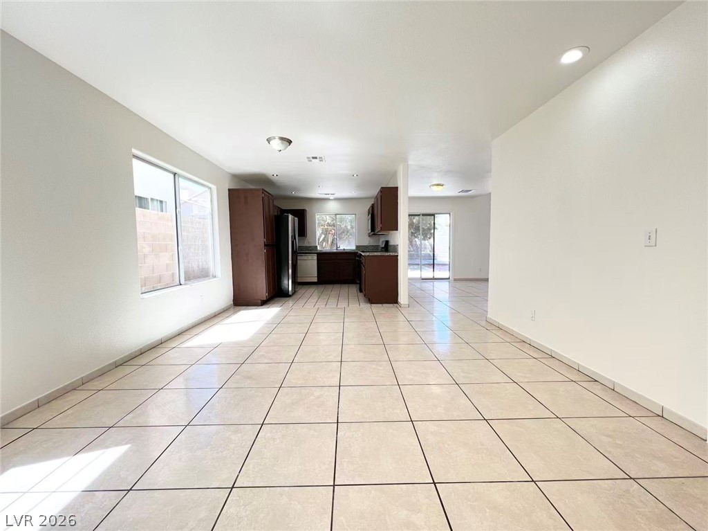 8284 West Rochelle Avenue Las Vegas, NV 89147 - Photo 6 of 29 A spacious layout connects the living area to a functional kitchen, all anchored by gleaming tile flooring.