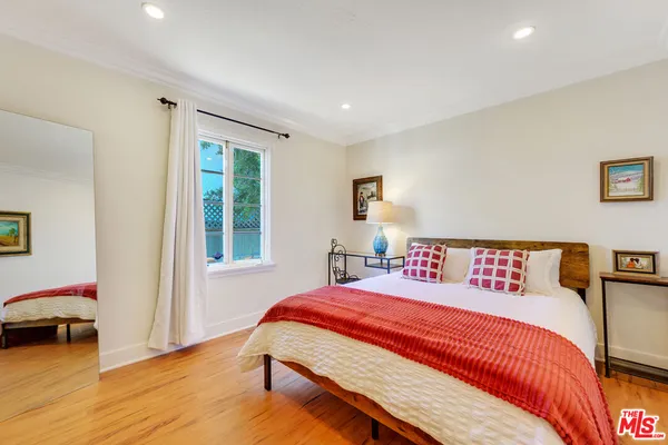 a bedroom with a bed a table and a large window