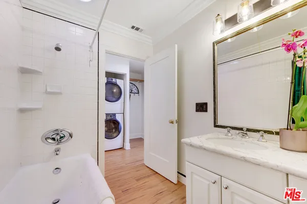 a bathroom with a tub sink and mirror
