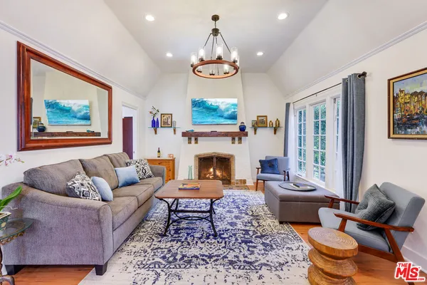 a living room with furniture a fireplace and a large window