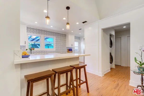 a kitchen with stainless steel appliances a table chairs refrigerator and sink