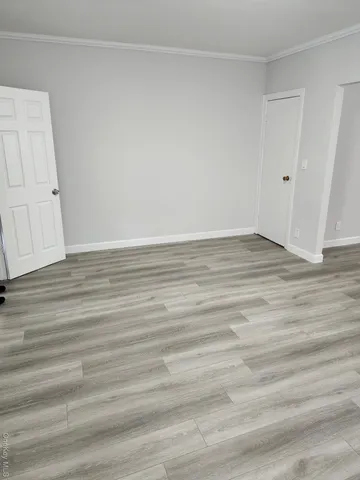 a view of an empty room with wooden floor