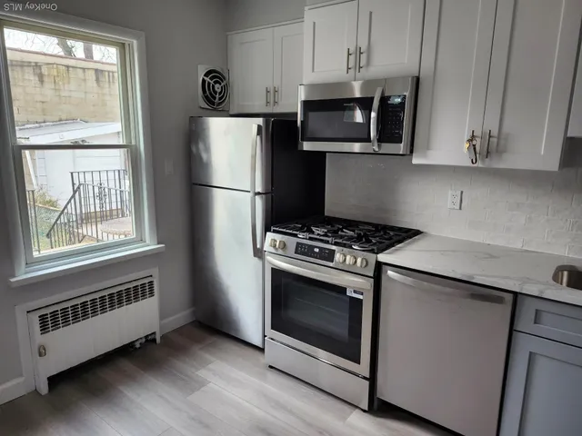 a kitchen with stainless steel appliances a stove a microwave and a refrigerator
