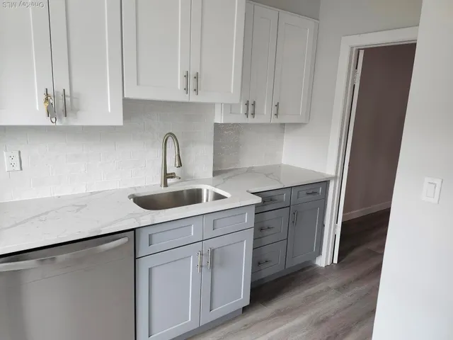 a kitchen with white cabinets appliances and sink