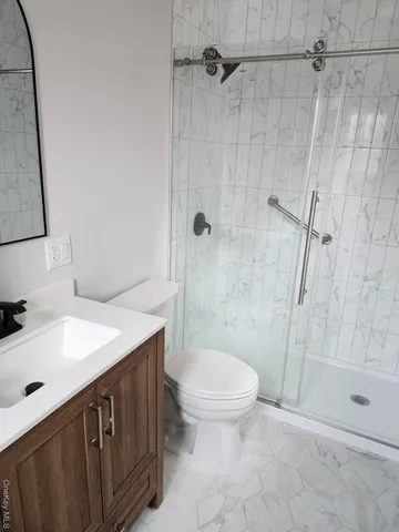a bathroom with a sink a toilet and shower