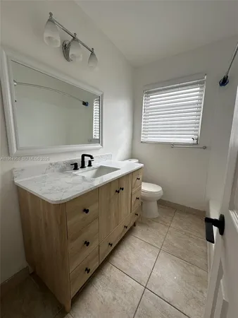 a bathroom with a sink a toilet and mirror