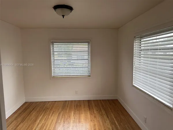 a view of a room with wooden floor and window