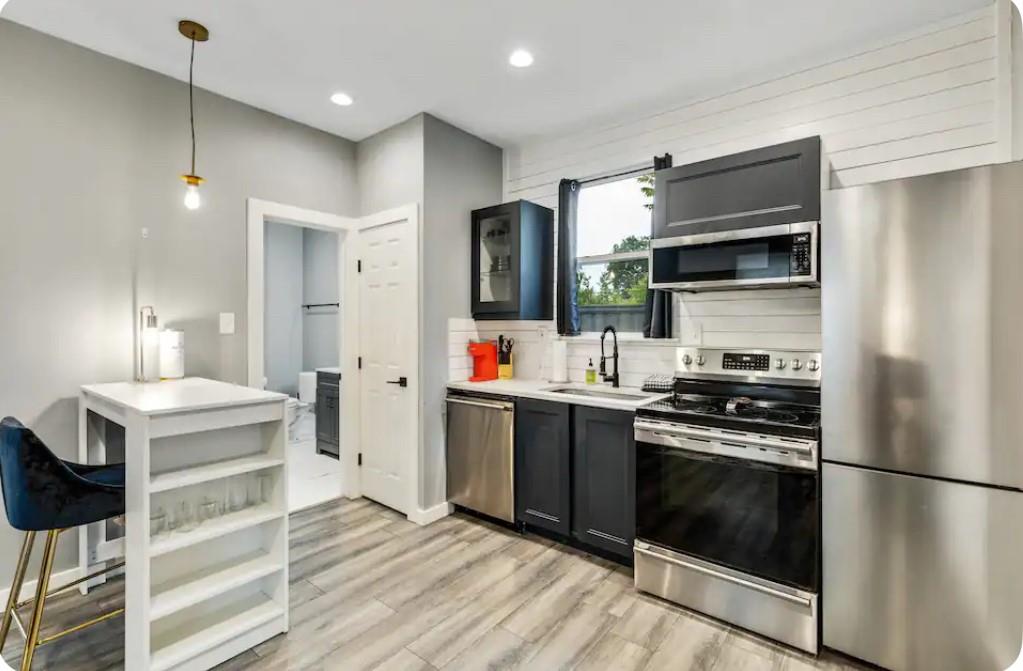1606 West 12th Street Dallas, TX 75208 - Photo 15 of 20 Kitchen with appliances with stainless steel finishes, pendant lighting, decorative backsplash, recessed lighting, and light wood-style flooring