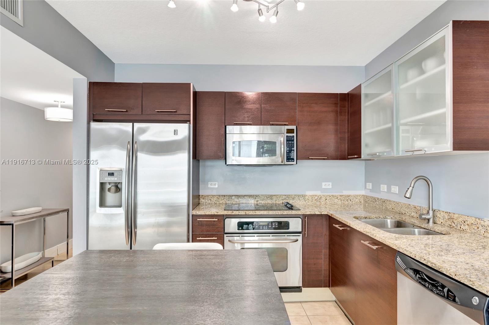 41 Southeast 5th Street, Unit 1212 Miami, FL 33131 - Photo 16 of 37 a kitchen with stainless steel appliances granite countertop a sink stove and refrigerator