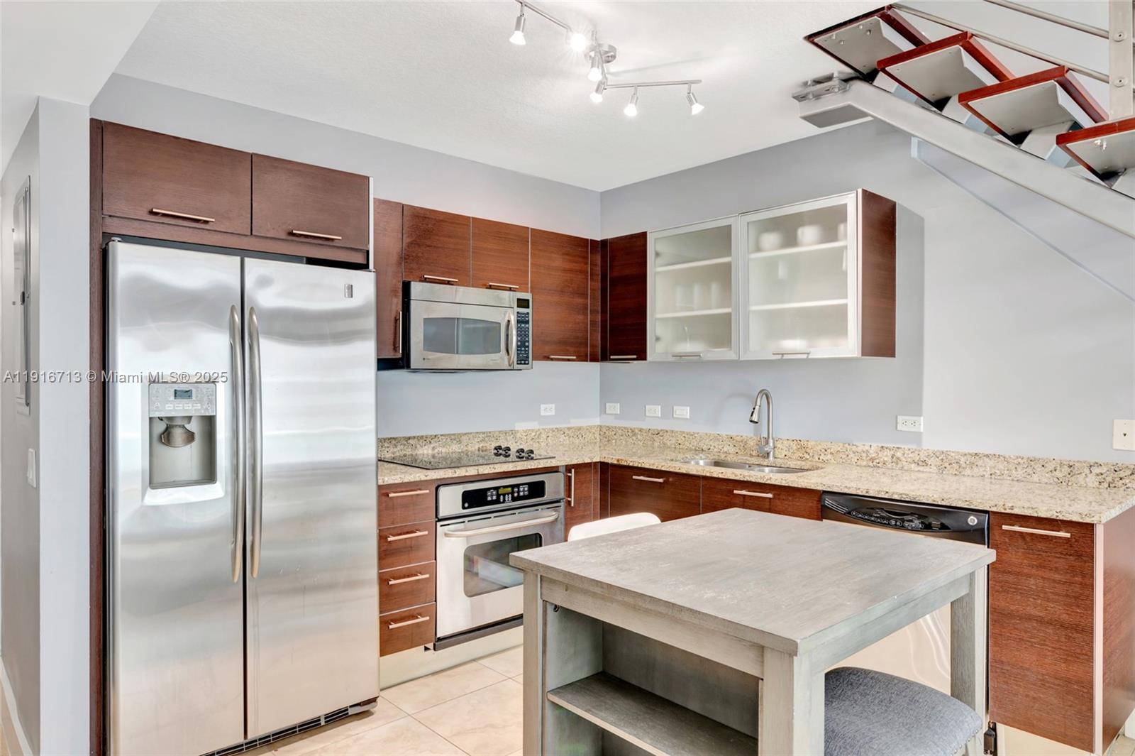 41 Southeast 5th Street, Unit 1212 Miami, FL 33131 - Photo 17 of 37 a kitchen with a sink stove and refrigerator