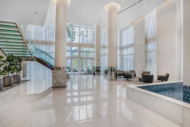 a lobby with furniture and floor to ceiling windows