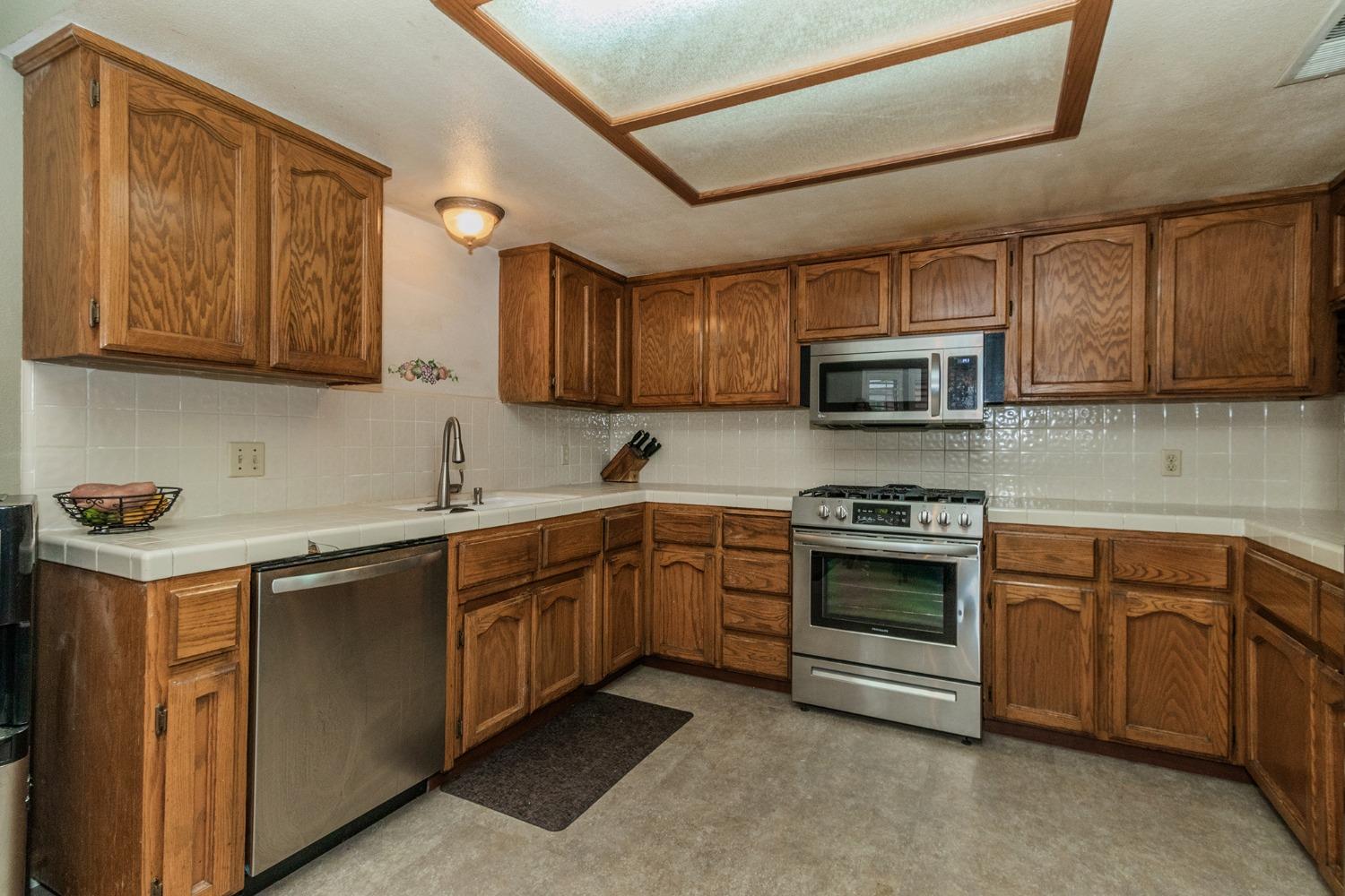 3440 Olive Street Selma, CA 93662 - Photo 7 of 21 a kitchen with stainless steel appliances granite countertop a stove sink microwave and cabinets