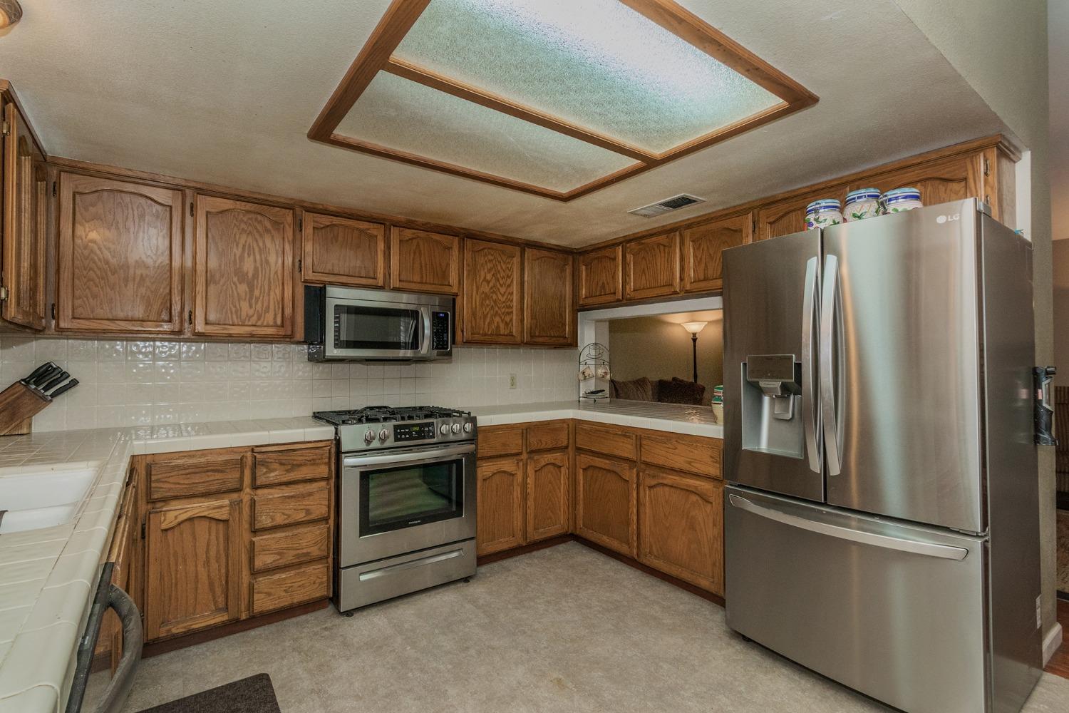 3440 Olive Street Selma, CA 93662 - Photo 8 of 21 a kitchen with stainless steel appliances granite countertop a refrigerator sink and microwave