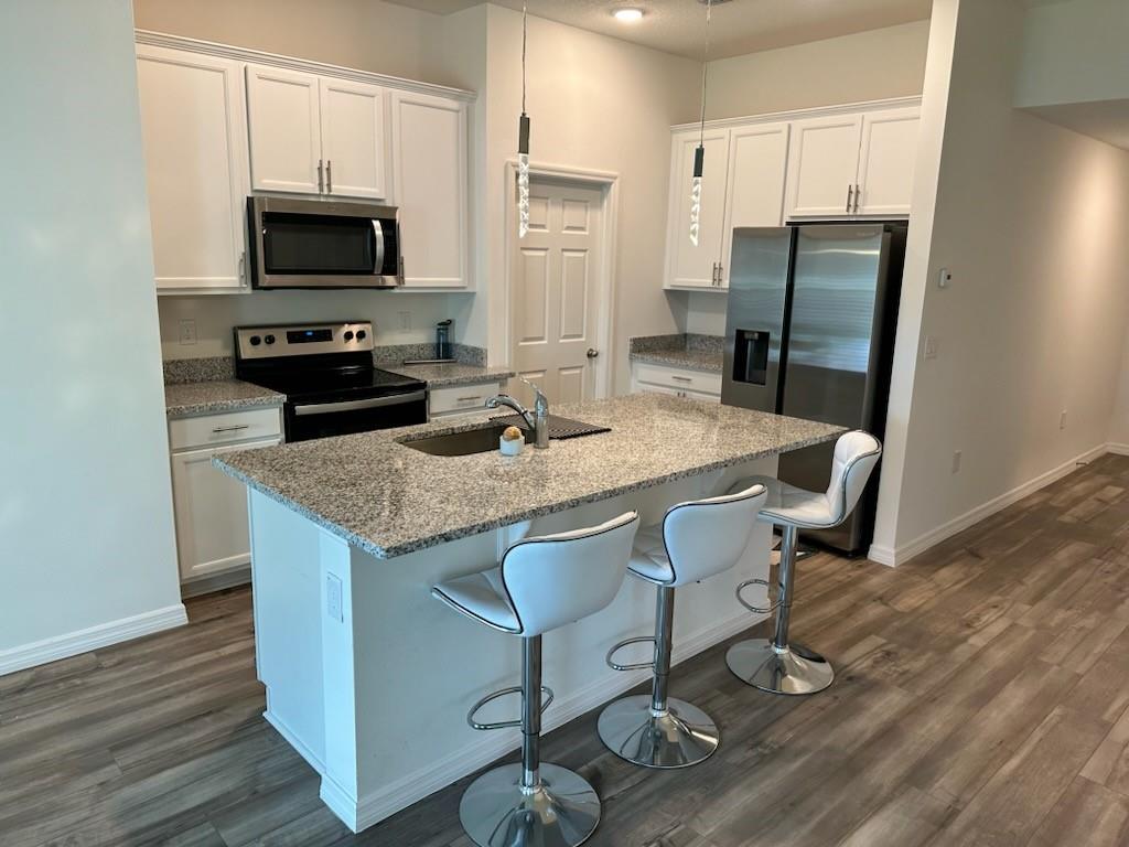 1099 Dania Circle Palm Bay, FL 32905 - Photo 2 of 17 a kitchen with a granite counter top space appliances and wooden floor