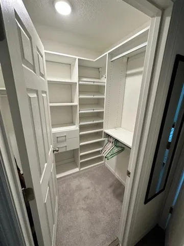 a view of walk in closet with empty racks