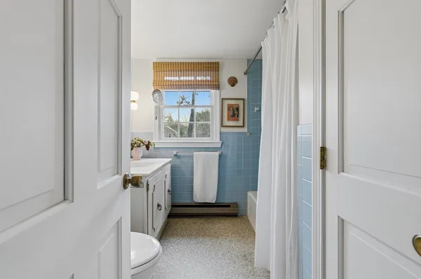 a bathroom with a sink a toilet and a window