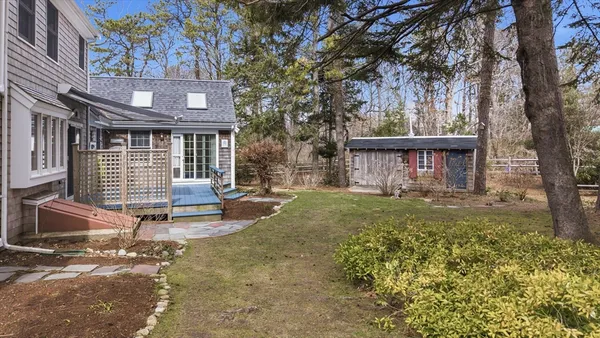 a view of a house with backyard and a tree
