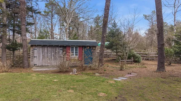 a view of a house with large window and wooden fence