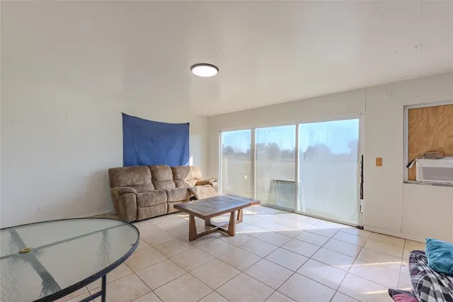 a living room with furniture and a floor to ceiling window