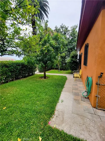 a front view of a house with a yard and trees