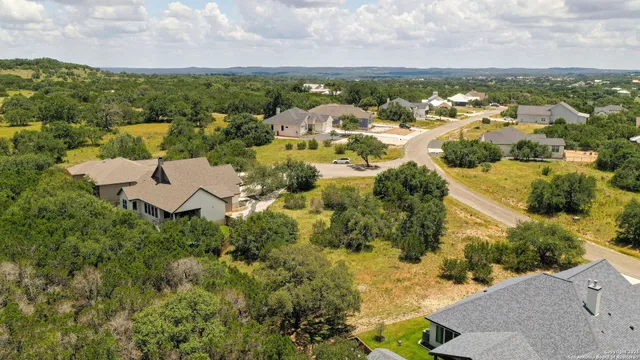 an aerial view of residential houses with outdoor space and trees