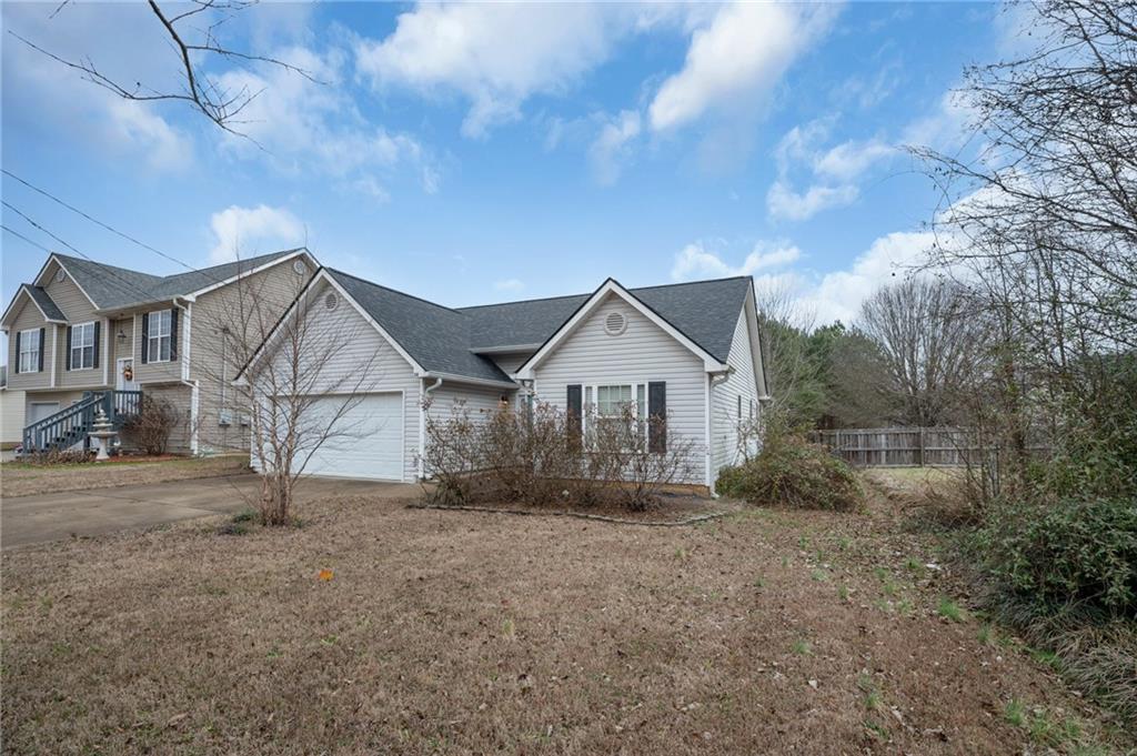a view of a house with large trees and wooden fence