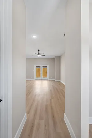 a view of an empty room with wooden floor and a window