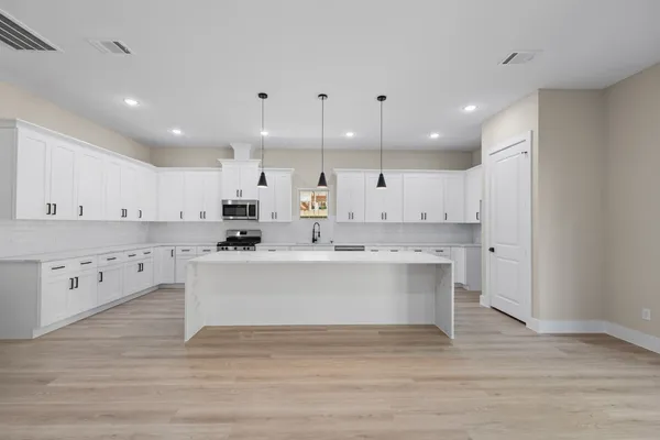 a view of kitchen with kitchen island a sink dishwasher stove with wooden floors