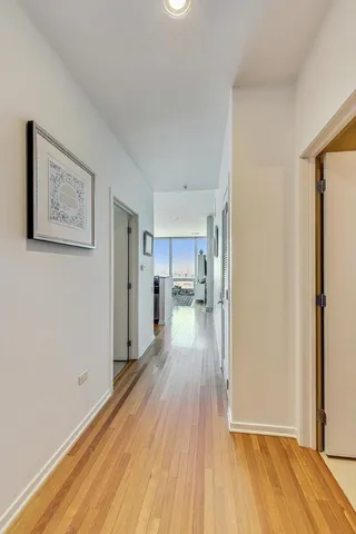 a view of a room with wooden floor and a kitchen