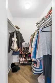 a view of walk in closet with clothes and shoes