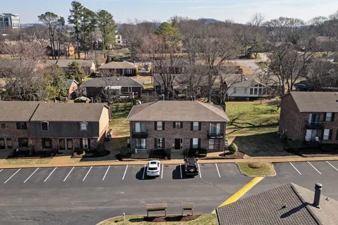 a view of a patio with couches and a table and chairs under an umbrella