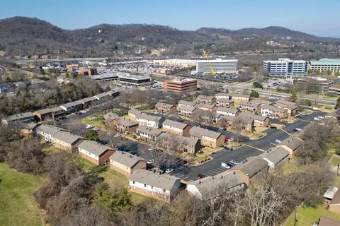 an aerial view of residential houses with outdoor space and trees