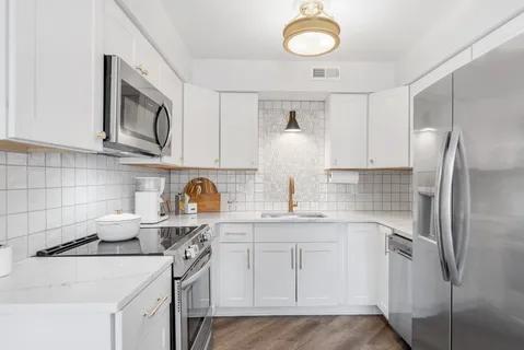 a kitchen with stainless steel appliances granite countertop a sink stove and refrigerator