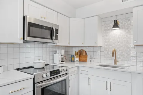 a kitchen with appliances a sink and cabinets