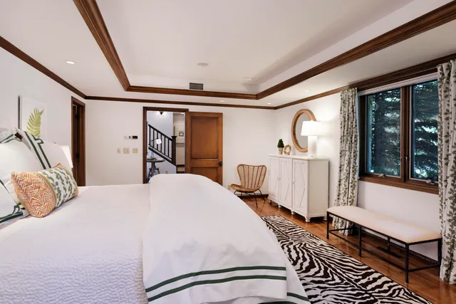a bedroom with a bed wooden floor and window