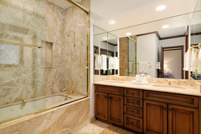 a bathroom with a granite countertop sink mirror and shower
