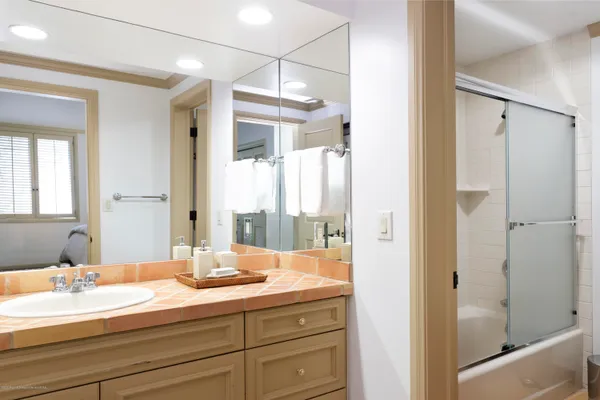 a bathroom with a double vanity sink and mirror with shower