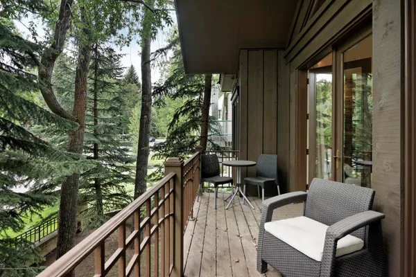 a view of balcony with chairs and wooden fence