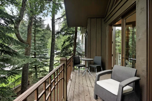 a view of balcony with chairs and wooden fence