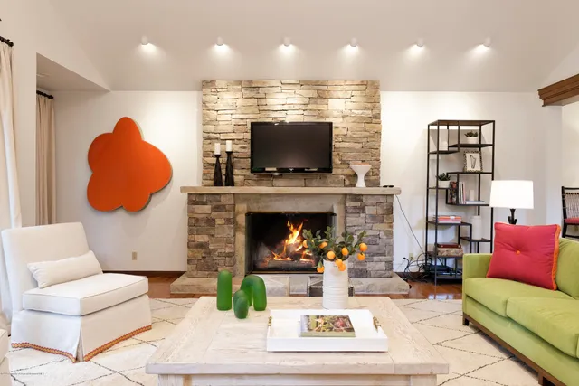 a living room with furniture a fireplace and a flat screen tv
